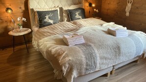 A cozy wooden room with a large bed, two nightstands, and a dreamcatcher. - Luxury chalet with panoramic views in the Lötschental, with private carport  (Kippel)