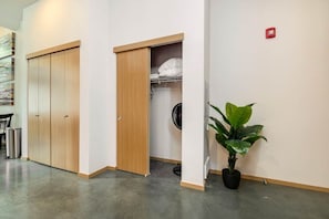 Un corridoio con un'armadiatura in legno, una cabina armadio e una pianta in vaso.