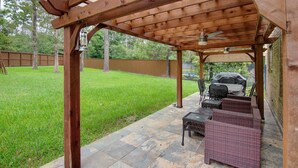 A wooden pergola with a patio area featuring wicker furniture and a grill. - Super COZY 4 bdr home w beautiful gazebo terrace!! (Magnolia)