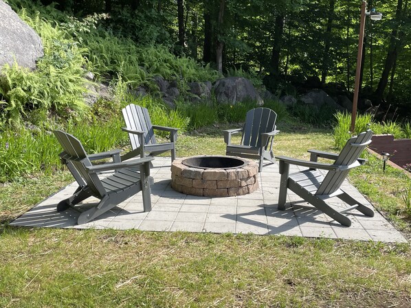 A fire pit surrounded by Adirondack chairs on a patio. - “Hollywood Nights” (Old Forge)