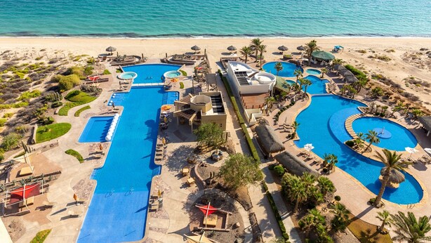 A resort with multiple swimming pools, beach access, and palm trees. - Encanto Living 1104 by Kivoya (Puerto Peñasco)