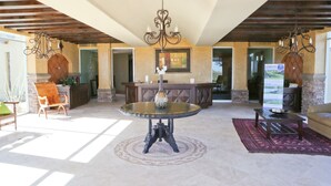 A spacious lobby with a round table, a chandelier, and a fireplace. - Encanto Living 1104 by Kivoya (Puerto Peñasco)