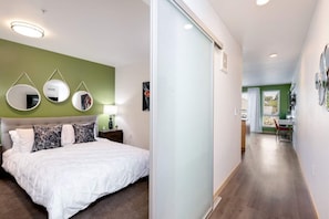 Una camera da letto moderna con un letto, comodini e una parete verde a contrasto.