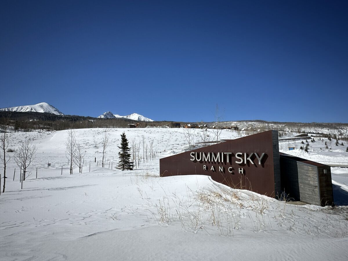 Un paysage enneigé avec un panneau indiquant « Summit Sky Ranch ».