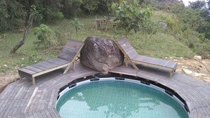 Un bain à remous doté d’une terrasse en bois et de deux chaises longues.