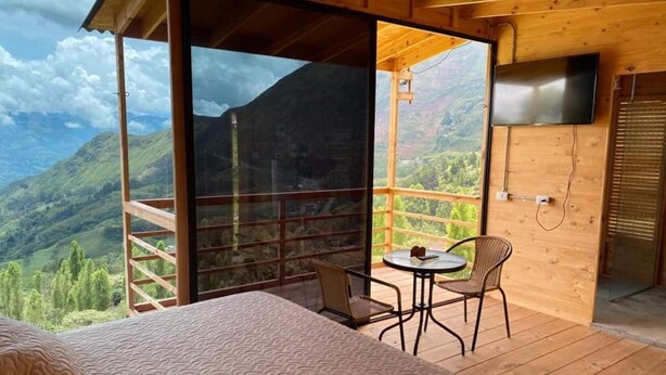 Une chambre avec une grande fenêtre donnant sur un paysage montagneux.
