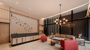 Ein modernes Wohnzimmer mit einer großen, wandmontierten Anzeige, einem Sofa, zwei roten Sesseln und einem Couchtisch.