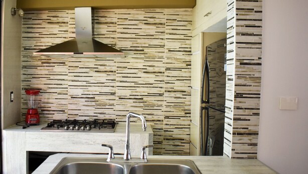 A modern kitchen with a double sink, a gas stove, and a stainless steel range hood. - Casa Mosha 2 La Mejor Atención, Cerca de Todo (benito juarez)