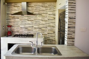 A modern kitchen with a double sink, a gas stove, and a stainless steel range hood. - Casa Mosha 2 La Mejor Atención, Cerca de Todo (benito juarez)