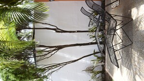 A patio area with a table and chairs, surrounded by palm trees and a tiled floor. - Casa Mosha 2 La Mejor Atención, Cerca de Todo (benito juarez)
