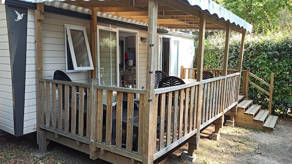 A wooden deck with a covered seating area, a small porch, and a staircase leading to an upper level. - Mobile home for 4 people, 2 bedrooms, 300 m from the beach (Saint-Brevin-les-Pins)