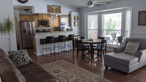 A spacious living room with a large gray sofa, a coffee table, and a patterned rug.