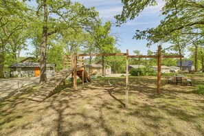 A playground with a wooden swing set, a slide, and a climbing structure. - Pool Access! Waterfront Home on Table Rock Lake (Reeds Spring)
