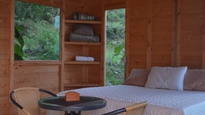 Een houten kamer met een bed, een tafel en stoelen.