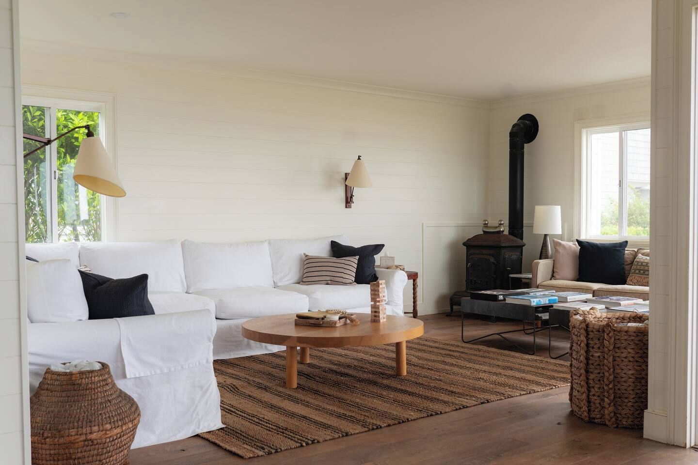 A living room with a white sofa, a round coffee table, and a fireplace.