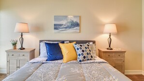Een slaapkamer met een bed, twee nachtkastjes en een aan de muur hangend schilderij.