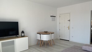 Un salon moderne avec un téléviseur à écran plat, une table basse et un canapé.