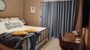 A bedroom with a bed, a desk, a chair, a ceiling fan, a TV, and a window with curtains. - 3 MIN. WALK TO THE BEACH!  South Nags Head  (Nags Head)