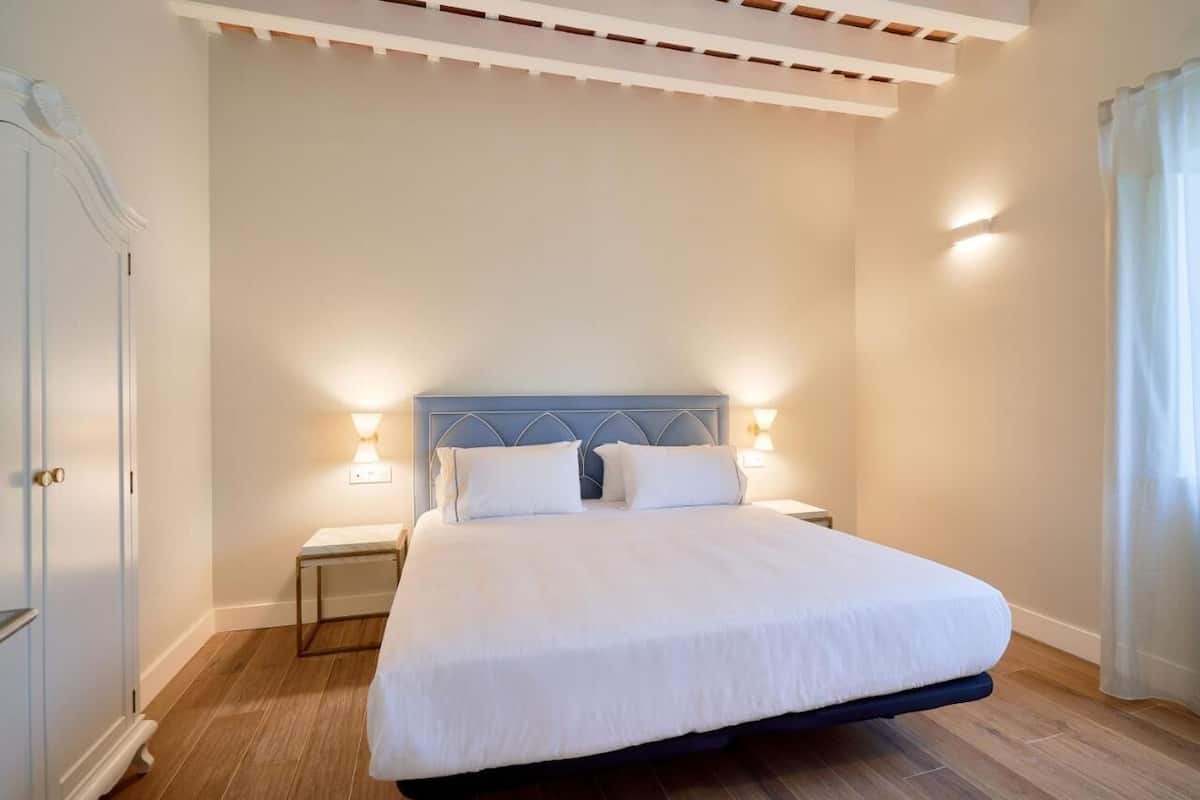 A bedroom with a bed, nightstands, and a wardrobe.