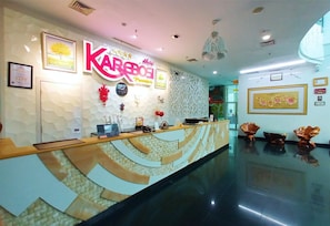 Un'area reception di un hotel dal design moderno, con scrivania, opere d'arte incorniciate e elementi decorativi.