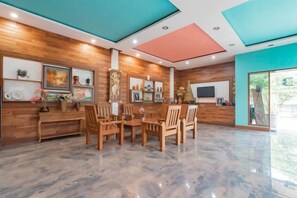 Una habitación espaciosa con pared de madera, suelo de mármol y un gran ventanal.