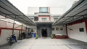 A building with a sign reading "KOST EXCLUSIVE MALEO" and a covered parking area with motorcycles. - Hotel O Seturan Near Hartono Mall Yogyakarta Formerly Maleo Kostel (Depok)