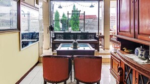 Une pièce comprenant une table à manger, deux chaises, un canapé et un meuble.
