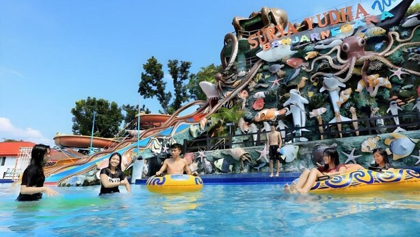 Parque acuático con un gran mural de criaturas marinas y un letrero que dice 'YUDHA WATER PARK'.