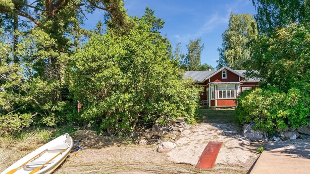 A riverside property with a dock, a wooden boat, and a house with a red roof. - Vacation home Elfvik by Interhome (Porvoo)