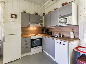 A compact kitchen with a refrigerator, stove, oven, microwave, and dishwasher. - Vacation home Elfvik by Interhome (Porvoo)