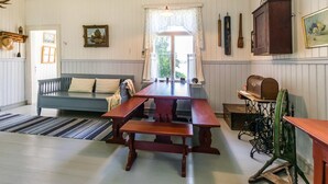 A room with a wooden bench, a sofa, a table, and a window with curtains. - Vacation home Elfvik by Interhome (Porvoo)