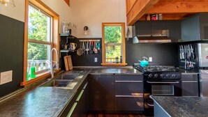 Una cocina moderna con una isla central, electrodomésticos de acero inoxidable y vigas de madera.