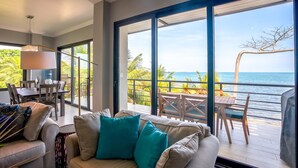 Una stanza moderna con un'ampia porta-finestra scorrevole che si apre su un balcone con vista sul mare.