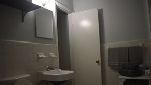 Une salle de bain avec un lavabo blanc, des toilettes et un porte-serviettes.