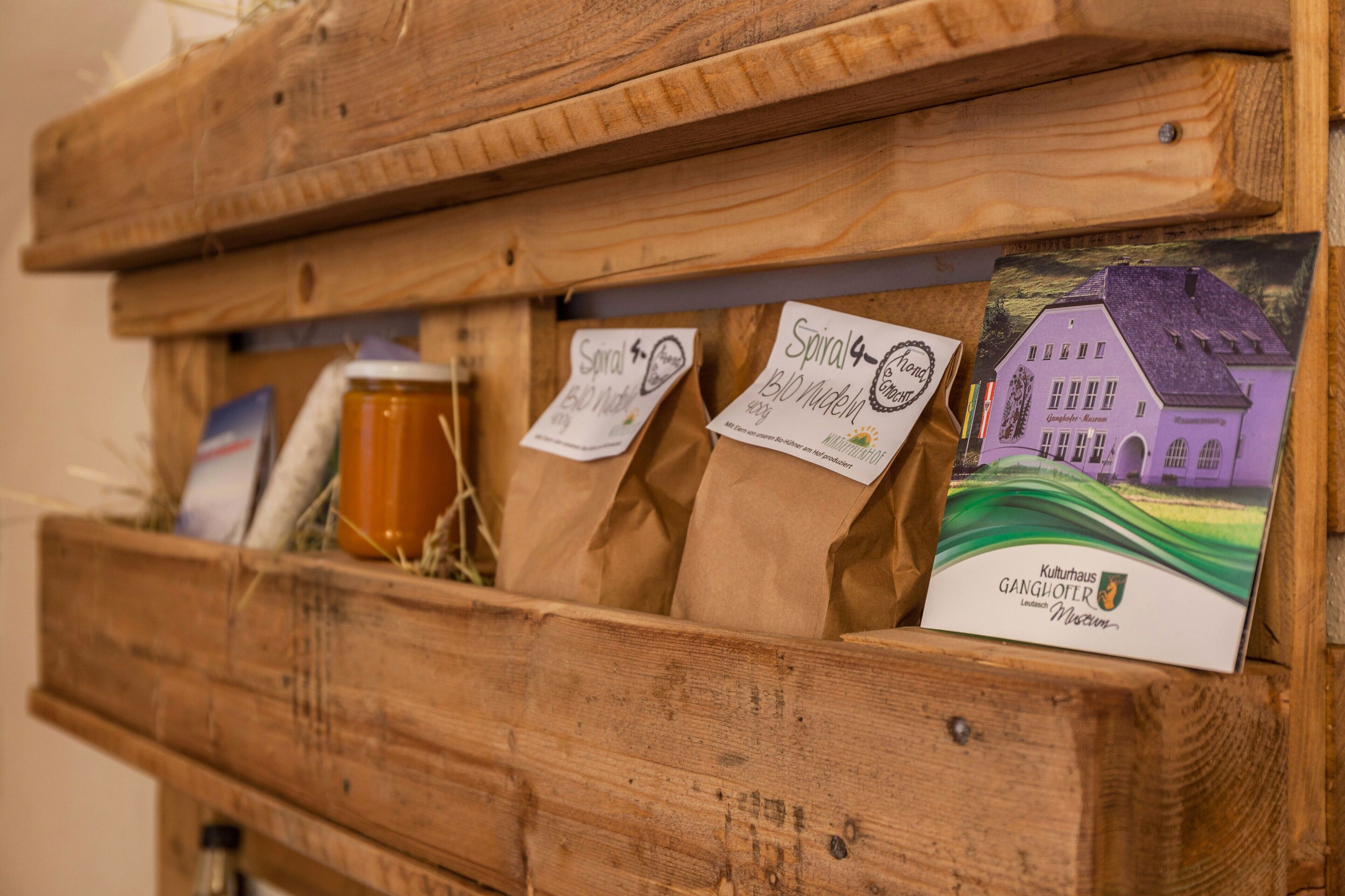 A wooden display case with labeled bags and a postcard.