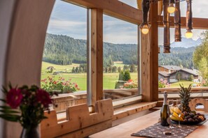 A wooden interior with large windows offering a view of a green landscape and a mountain. - Vacation Home 'Panorama Lodge Leutasch' with Mountain View, Terrace & Sauna (Leutasch)
