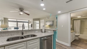 Una cucina moderna con lavastoviglie, ventola a soffitto e un'ampia finestra.