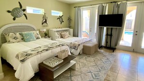 A bedroom with two beds, a TV, and a view of the outside. - Luxurious 3 Story Townhome, private pool, Elevator, 3 minute walk to the beach!! (South Padre Island)
