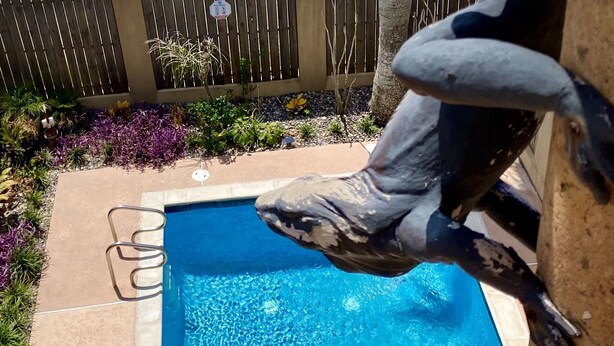 A swimming pool with a diving board and a stone structure. - Luxurious 3 Story Townhome, private pool, Elevator, 3 minute walk to the beach!! (South Padre Island)