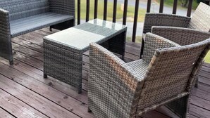 A wooden deck with wicker furniture, including a sofa, armchairs, and a coffee table. - Perfect Lake Escape (Holiday Island)