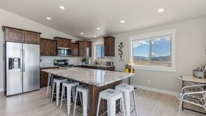 Una cocina moderna con una isla grande, electrodomésticos de acero inoxidable y armarios de madera.