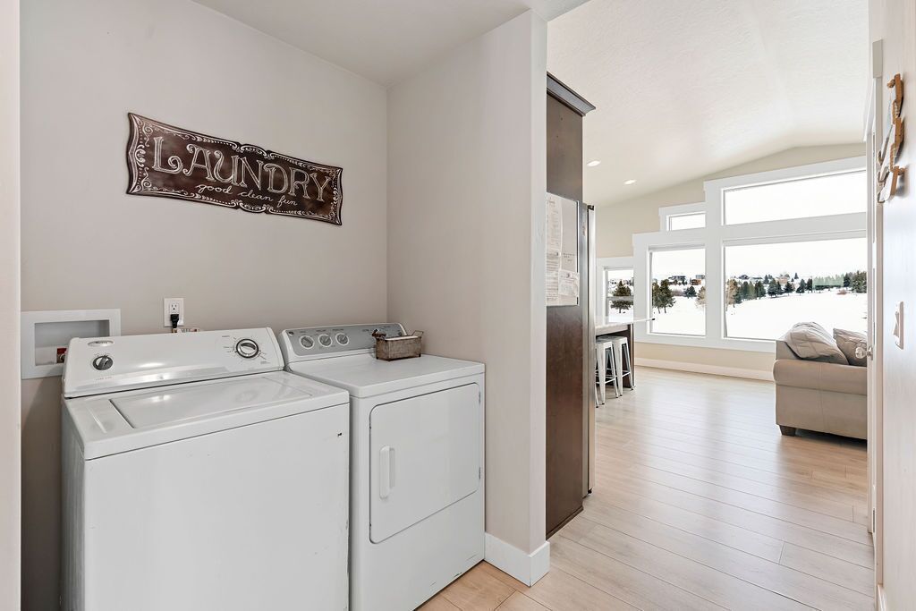 A laundry room with two white washing machines, a drying rack, and a sign that reads "Laundry".