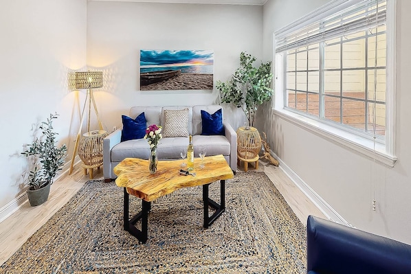 A living room with a sofa, coffee table, and decorative items.