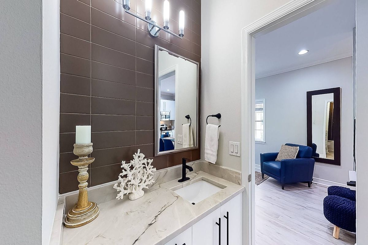 A bathroom with a large mirror, a sink, and a decorative candle holder.