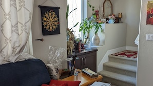 Un salon comprenant un canapé, une table basse et un escalier menant à un niveau supérieur.
