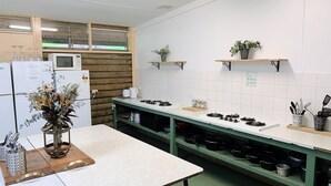 Une cuisine dotée d’un long comptoir, d’un four à micro-ondes, d’un réfrigérateur et de divers ustensiles.
