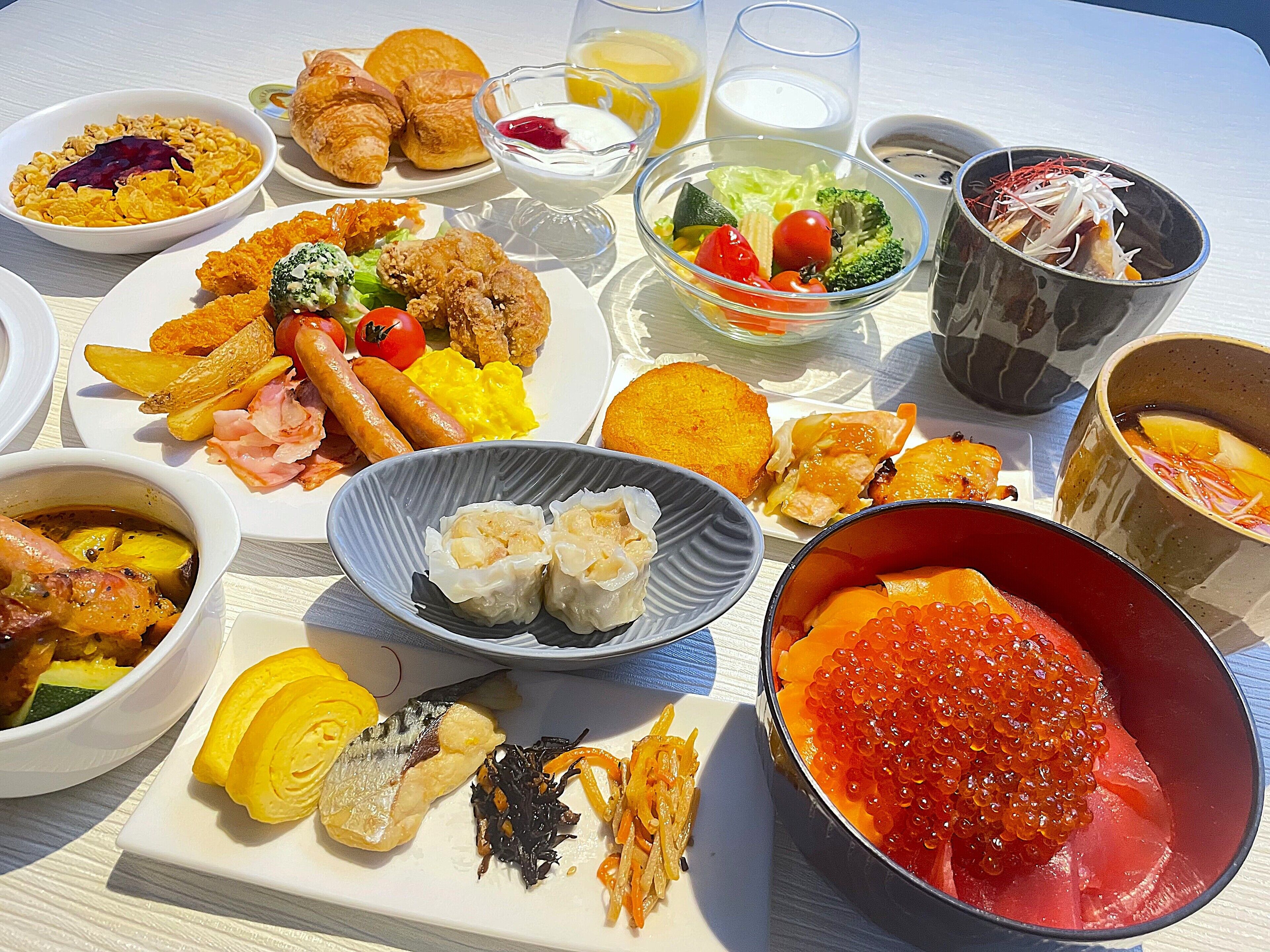 A variety of dishes including seafood, vegetables, and pastries on a table.