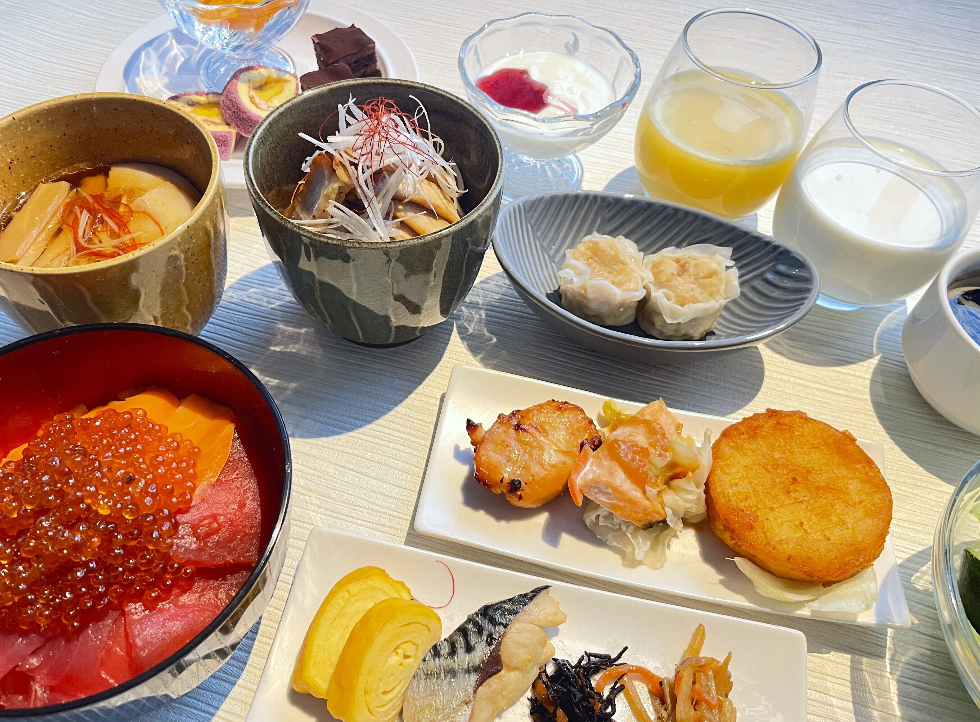A variety of dishes including sashimi, tempura, and a bowl of red caviar.