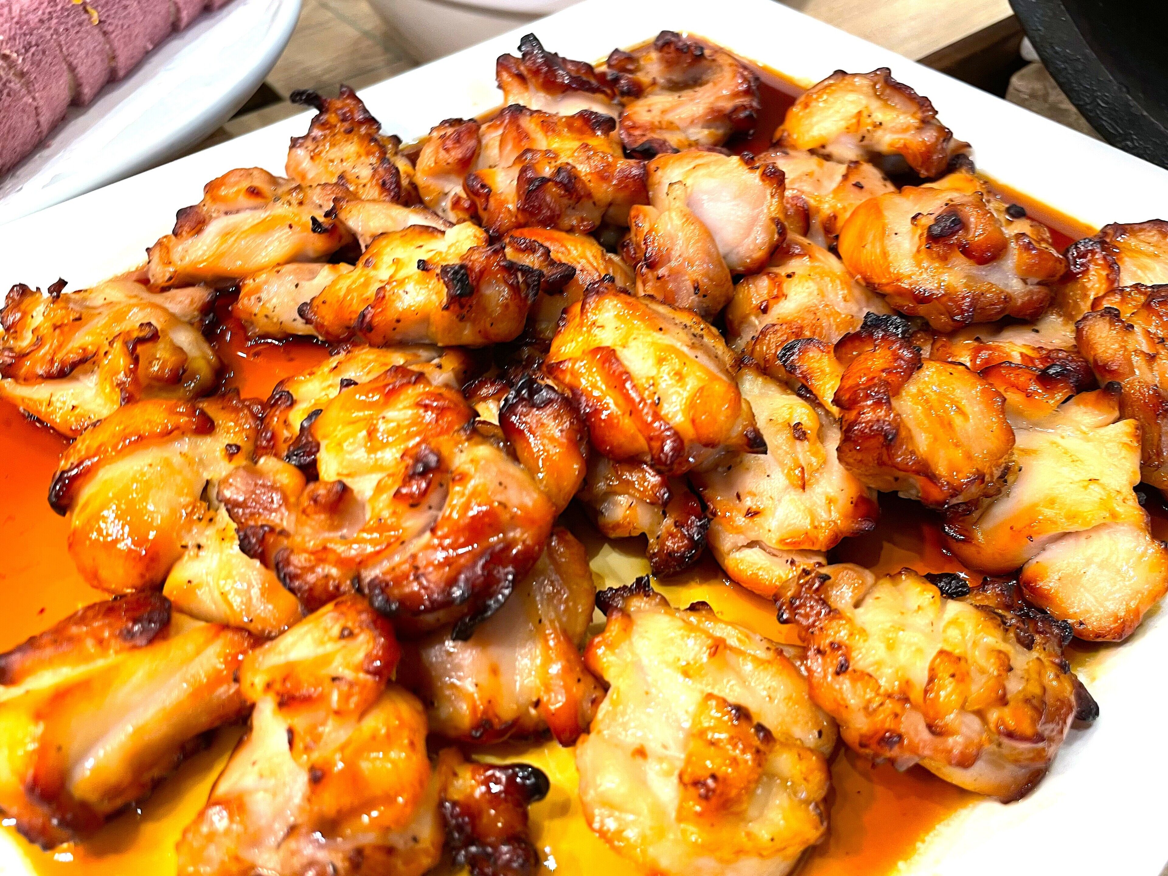 A plate of grilled chicken with a glossy sauce.
