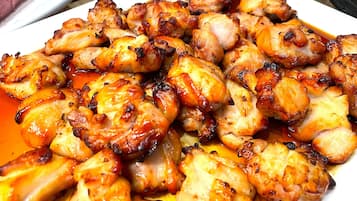 A plate of grilled chicken with a glossy sauce.